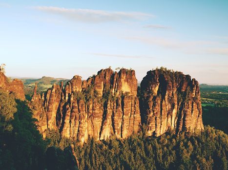 Morning sunlight on rocky towers of Schrammsteine in national park Saxony Switzerland, Germany. Popular climbers resort. Deep cracks in rocks donne by strong rain erosion.