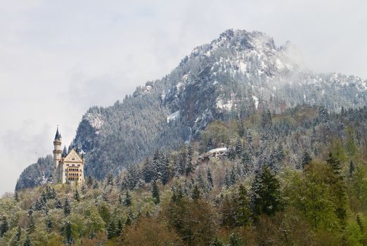 Old castle in mountais, rocks and forest covered with fresh snow and hoarfrost, winter with snow return in spring mountains.