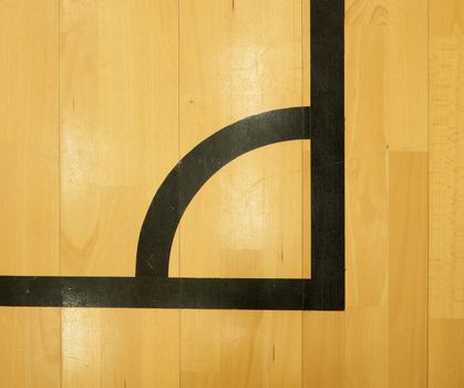 Black corner. Worn out wooden floor of sports hall with colorful marking lines