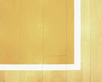 White corner and yellow field. Worn out wooden floor of sports hall with colorful marking lines