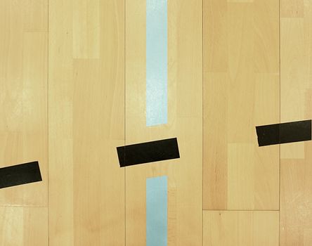 Black dotted lines in hall playground. Worn out wooden floor of sports hall with colorful marking lines. Schooll gym hall