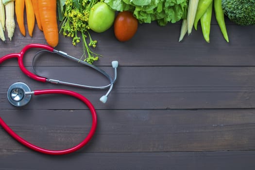 Healthy food, vegetables organic on wooden background with glass of milk and stethoscopes, strong body concept and copy space below.