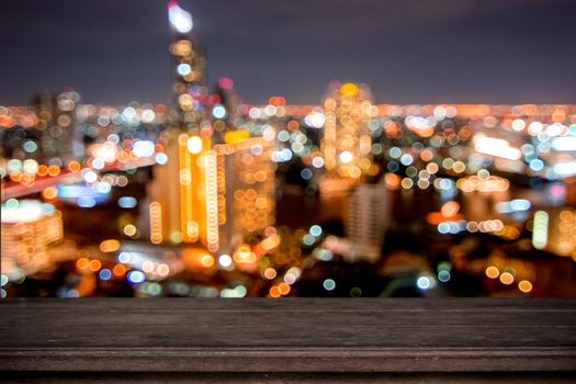 empty wood table on soft bokeh of light night city background, counter can be placed your produce 