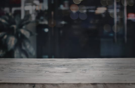 Old wood table in front of blurred cafe restaurant background, copy space can be placed your product.