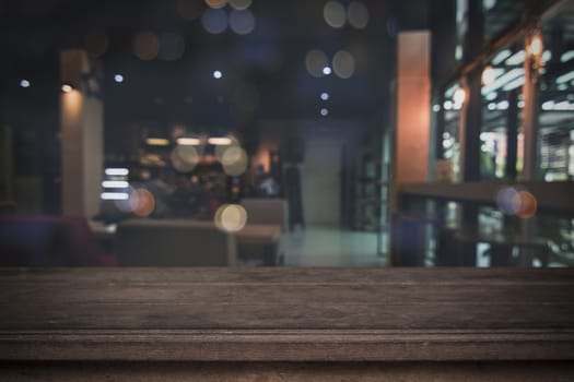 Old wood table in front of blurred cafe restaurant background, copy space can be placed your product.