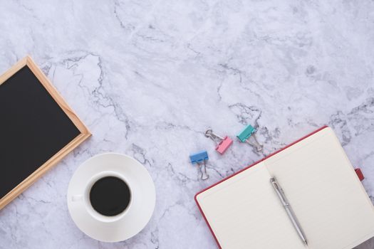 Flat lay creative and designer background with cup of coffee and office tools on white marble background 