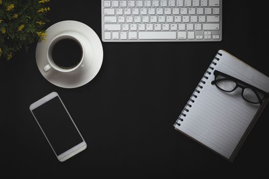 top view of coffee, notebook and office objects on black copy space background