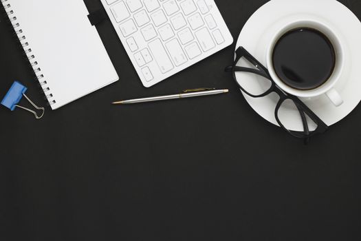 top view of coffee, notebook and office objects on black copy space background