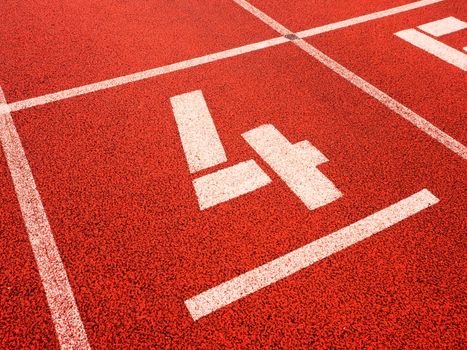 Number four. White track number on red rubber racetrack, texture of running racetracks in stadium