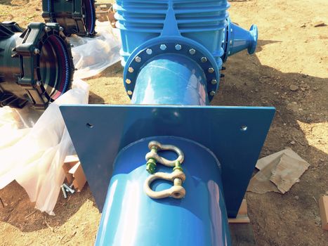 Big industrial gate valves in pipelines with big hand wheel. Repaired drink water pipeline in digged hole. The 500 mm diameter pipel.