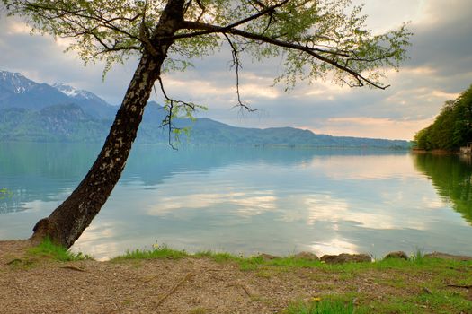 Mountains lake and low mountains with snowy peaks in water mirror. Lake in National Park.