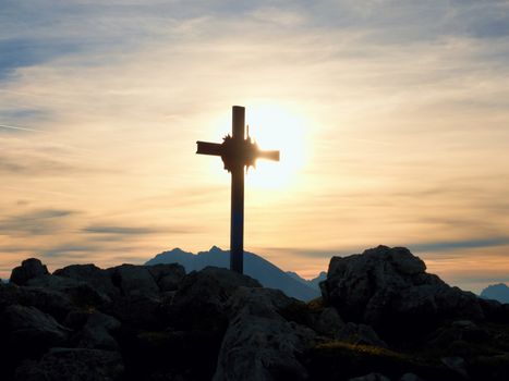 Iron cross at mountain top in alp. Cross on top of a mountains peak as typical in the Alps. Monument to the dead climbers