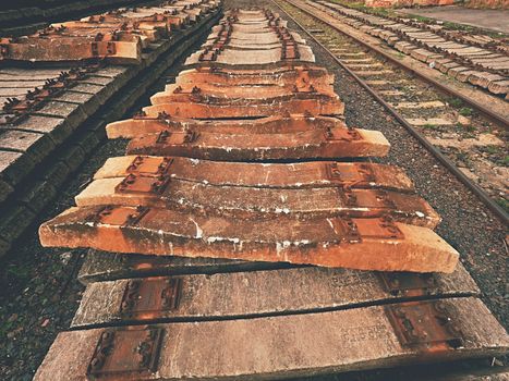 Used sleepers stock in railway depot. Old, dirty and rusty used concrete railway ties stored after big reconstruction of old railway station. 