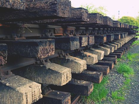 Wagon with old railways. Concrete and wooden sleepers extracted  with rail rods in railway station stock waiting for transport to steel foundry for recycling.