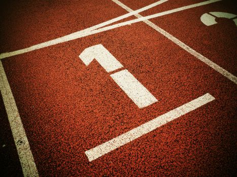 Number one. White track number on red rubber racetrack, texture of running racetracks in small stadium