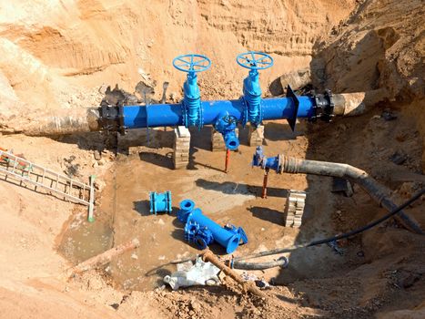 Drink Water Factory. Renewal underground pipelines, valve gates and metal pipes. Toned image. Repairing of pipeline underground.