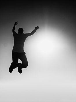 Flying man. Young man falling down over Sun in colorful sky. Silhouette of poise man and beautiful sunset sky. Element of design. Vintage effect.