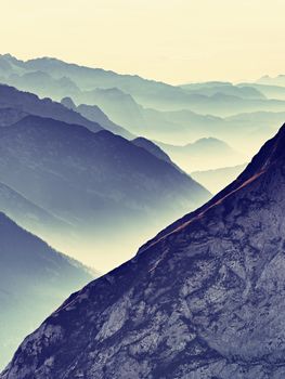 Contours of sharp mountains,  side by side increased from morning high humidity. Far view to daybreak horizon