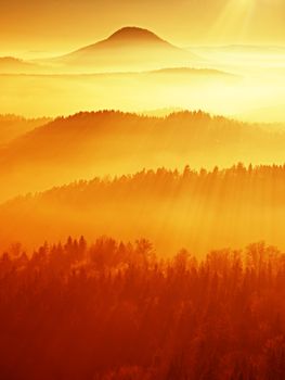 Red filter photo. Red daybreak. Misty daybreak in a beautiful hills. Peaks of hills are sticking out from foggy background, the fog is red and orange