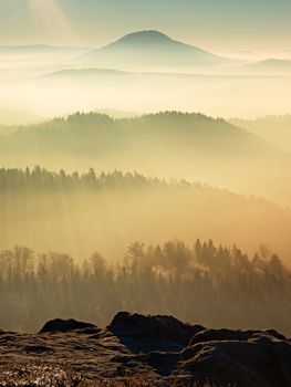 Fall daybreak. Misty awakening in a beautiful hills. Peaks of hills are sticking out from foggy landscape 