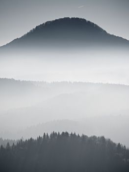 Silhouette view of mountains at sunset, national park. Dreamy fogy landscape, spring orange pink misty sunrise in a beautiful valley below. 