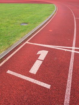 Number one. White track number on red rubber racetrack, texture of running racetracks in small stadium