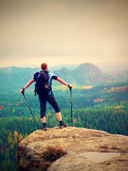 Hiker backpacker reaches the summit of mountain peak. Success, freedom and happiness, achievement in mountains