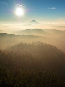 Fall daybreak. Misty awakening in a beautiful hills. Peaks of hills are sticking out from foggy landscape 