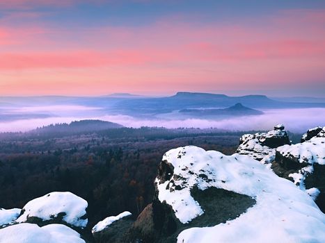 Red daybreak. Misty sunrise in the mountains, the gradation of color clouds. Misty daybreak in a beautiful hills. Peaks of hills are sticking out from foggy background, the fog is red and orange