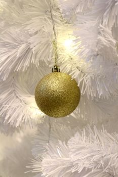 Golden ball on White Christmas tree background decoration (selective focus)
