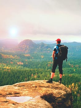 Hiker backpacker reaches the summit of mountain peak. Success, freedom and happiness, achievement in mountains