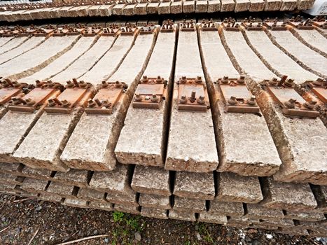 Used sleepers stock in railway depot. Old, dirty and rusty used concrete railway ties stored after big reconstruction of old railway station. 