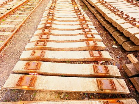 Extracted old concrete sleepers in stock. Old  rusty used concrete railway ties stored after big reconstruction of old railway station. 