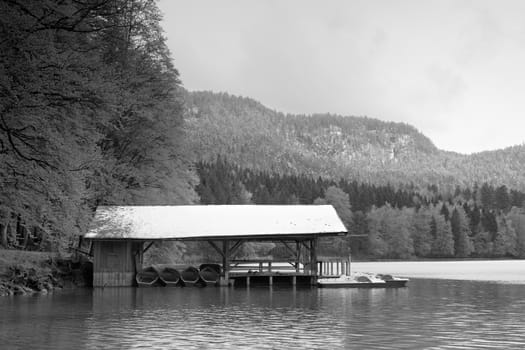 Snowy roof for holiday paddle boats. Mountain holiday resort on the shores of beautiful Alpine lake
