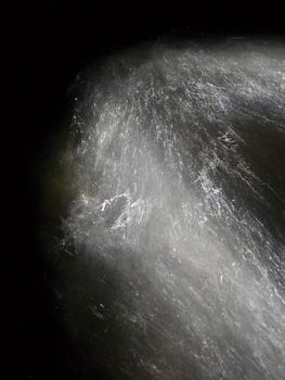 Shinning drops. Cascade of small weir on mountain stream, water is running over blocks and bubbles create milky smoky water level. Abstract, long exposure photo