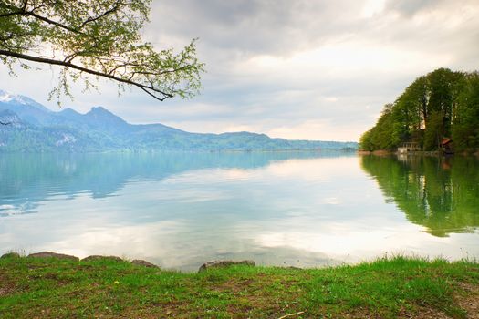 Alps lake shore. View on Alps mountains with white peaks mirror in lake level.. 