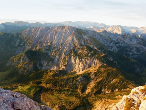 Sharp Alps peaks, rocks without people. View over Alpine rocks above deep vallyes to far horizon. Sunny day with clear blue sky  