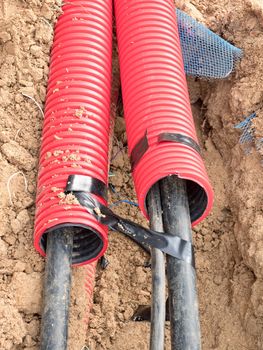 Wire in HDPE and protectivep tube. Building of lines of metallic and fiber optic cables, construction of communication optical network connection. Excavation of trench by hand or mechanized excavator and installation.