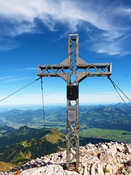 Praying summit cross on high rocky mountain. Steel artistic crucifix on top of Alpine mountain,  in the Dolomite Alps 