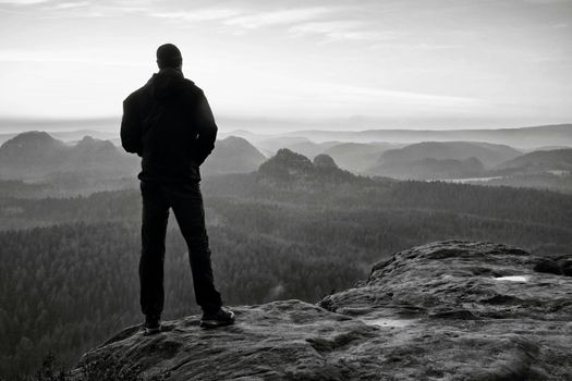 Tourist on the cliff of rock in rock empires park is watching over the misty and foggy morning valley to Sun