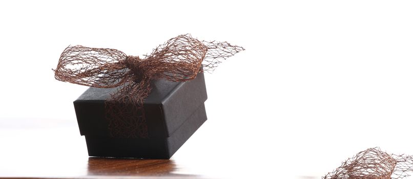 brown christmas present with ribbon. Presents in a table with decoration and copy space and a ribbon