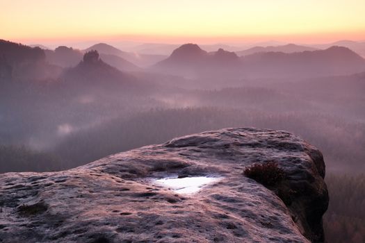 Dreamy spring daybreak above peaks of hilly lanscape with the view into misty valley. Vivid and vignetting effect.