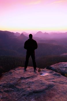 Tourist on the cliff of rock in rock empires park is watching over the misty and foggy morning valley to Sun