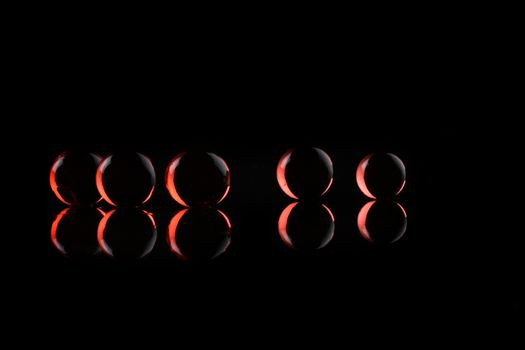 glowing red balls ob black background with reflection - concept shot with copy space