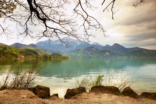 Mountains lake and low mountains with snowy peaks in water mirror. Lake in National Park.