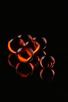 glowing red balls ob black background with reflection - concept shot. With copy space
