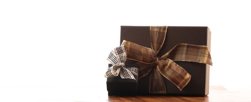 brown christmas present with ribbon. Presents in a table with decoration and copy space and a ribbon