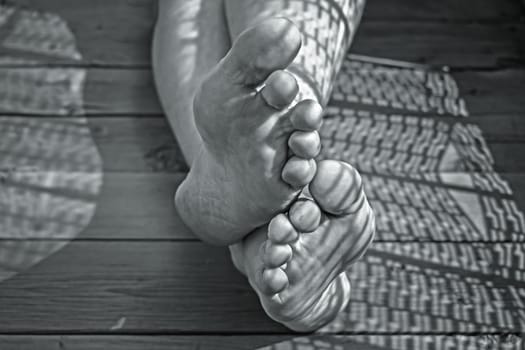 Dirty legs of a tired worker close-up on a wooden floor