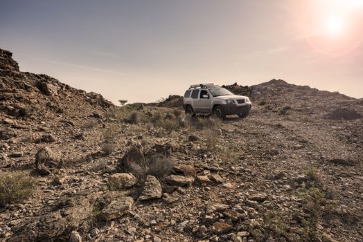 Adventure 4x4 driving rocky terrain and obstacles in arid mountains of the Sultanate of Oman, Middle East