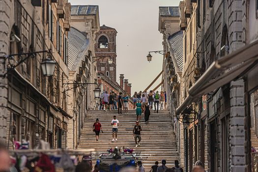 VENICE, ITALY 2 JULY 2020: Rialto bridge in Venice with people walking through